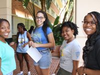 Click to show details - 10s - 2 students smiling outside of campbell hall