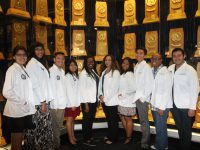 Click to show details - 10s - 8 students in front of trophies